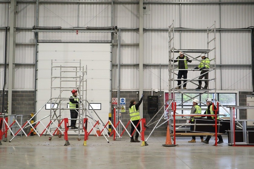 5 people in PPE going through PASMA training for the safe use of mobile scaffold towers