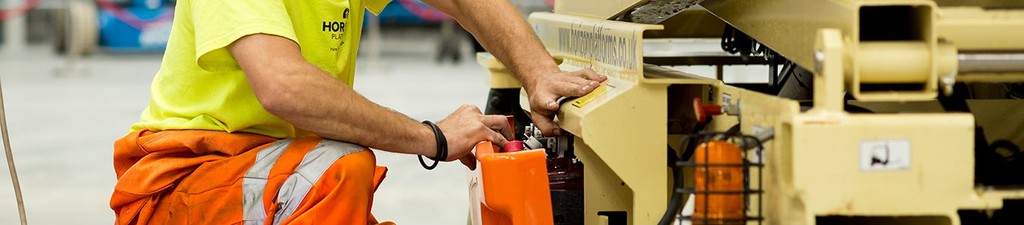 Am MEWP engineer from Horizon checking a scissor lift battery